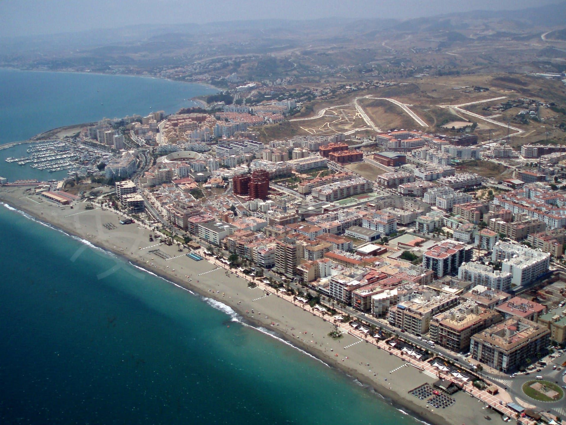 The plot can be seen to the left of the port in this photo, between the marina and the Playa del Cristo